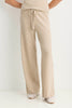 A person wearing light beige wide-leg knit pants with a drawstring waist, paired with a matching top and white shoes, shown against a plain white studio background.